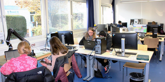 Studierende an Schreibtischen mit Computern in Study-LAB